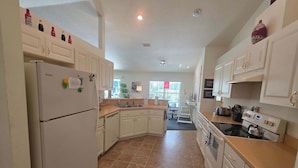 A kitchen with white cabinets, a refrigerator, a stove, and a sink. - Relaxing at the pool (Inverness)