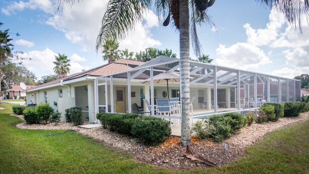 A house with a covered patio and a screened-in area. - Relaxing at the pool (Inverness)