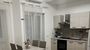 A modern kitchen with white cabinets, a gas stove, and a built-in oven. - Apartment in St. Peter  (Roma)