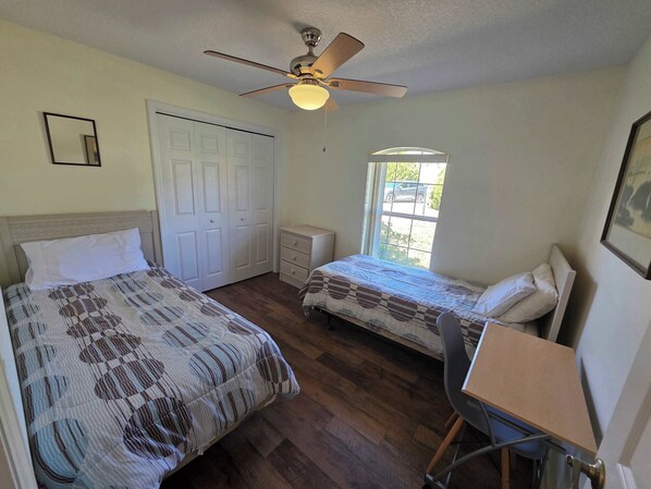 A bedroom with two beds, a ceiling fan, a window, and a desk. - Poolside Paradise Sum (Inverness)