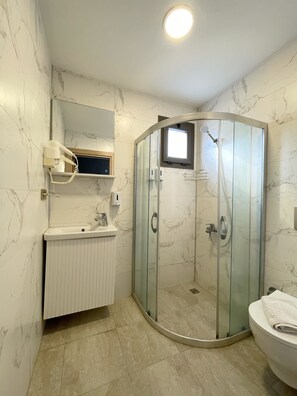 A bathroom with a glass-enclosed shower, a white sink, and a toilet. - AURORA SIĞACIK HOTEL (Seferihisar)