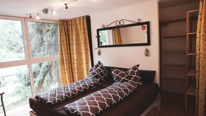 A room with a bed, a window, a mirror, and a wardrobe. - Ferienhäuser - Pappelallee (Biesenthal)