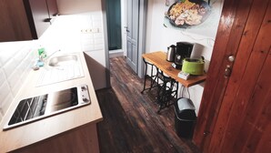 A compact kitchen with a sink, a toaster, and a coffee maker on a wooden table. - Ferienhäuser - Pappelallee (Biesenthal)