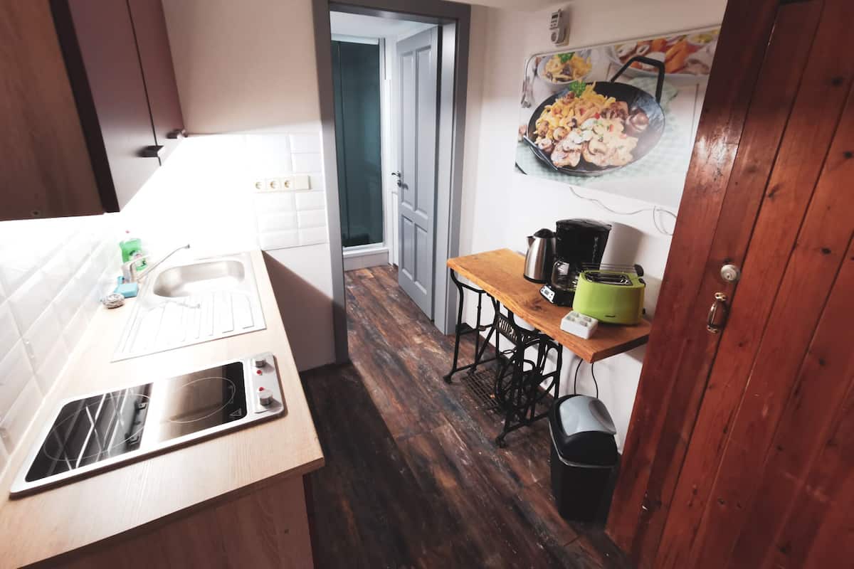 Eine kleine Küche mit Spüle, Toaster und Kaffeemaschine auf einem Holztisch.