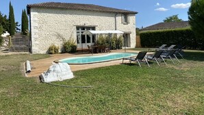 A stone house with a swimming pool, outdoor seating, and a well-maintained lawn. - Le Genet - Ancienne grange avec piscine privé (Chalais)