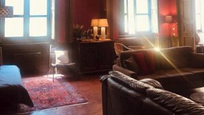 Een kamer met een grote spiegel, een bank en een lamp.