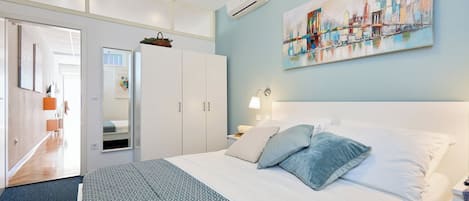 2 habitaciones, escritorio y tabla de planchar con plancha