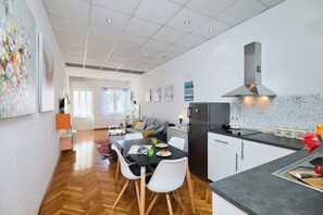 Eine moderne Küche mit Essbereich, Holzboden und einem großen Fenster.