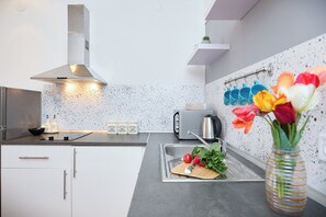 Eine moderne Küche mit einer Edelstahl-Dunstabzugshaube, einem Toaster und einer Spüle mit Schneidebrett.