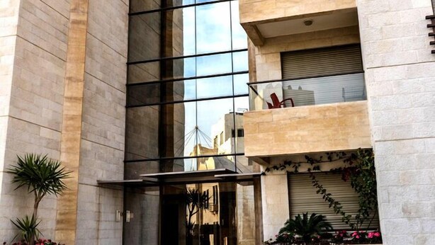 A modern building with a glass facade, multiple balconies, and a central entrance with steps. - Abdoun Panorama (Amman)