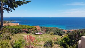A coastal landscape with a view of the sea, a garden with various plants, and a building with a tiled roof. - Casa di Toro, facing the sea, rated 4 *, swimming pools, Palombaggia beaches 1.9KM. (Porto-Vecchio)
