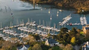 An aerial view of a coastal village with a marina, houses, and a bridge. - Charming house located on the marina (Bénodet)