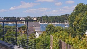A marina with boats, a bridge, and residential buildings in the background. - Charming house located on the marina (Bénodet)