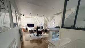 A modern interior with a dining area, kitchen, and living space. - Charming house located on the marina (Bénodet)