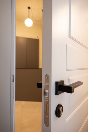 A modern door with a keycard reader, a lock, and a handle.