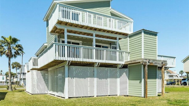 Ein zweistöckiges Haus mit Balkon und überdachter Veranda.