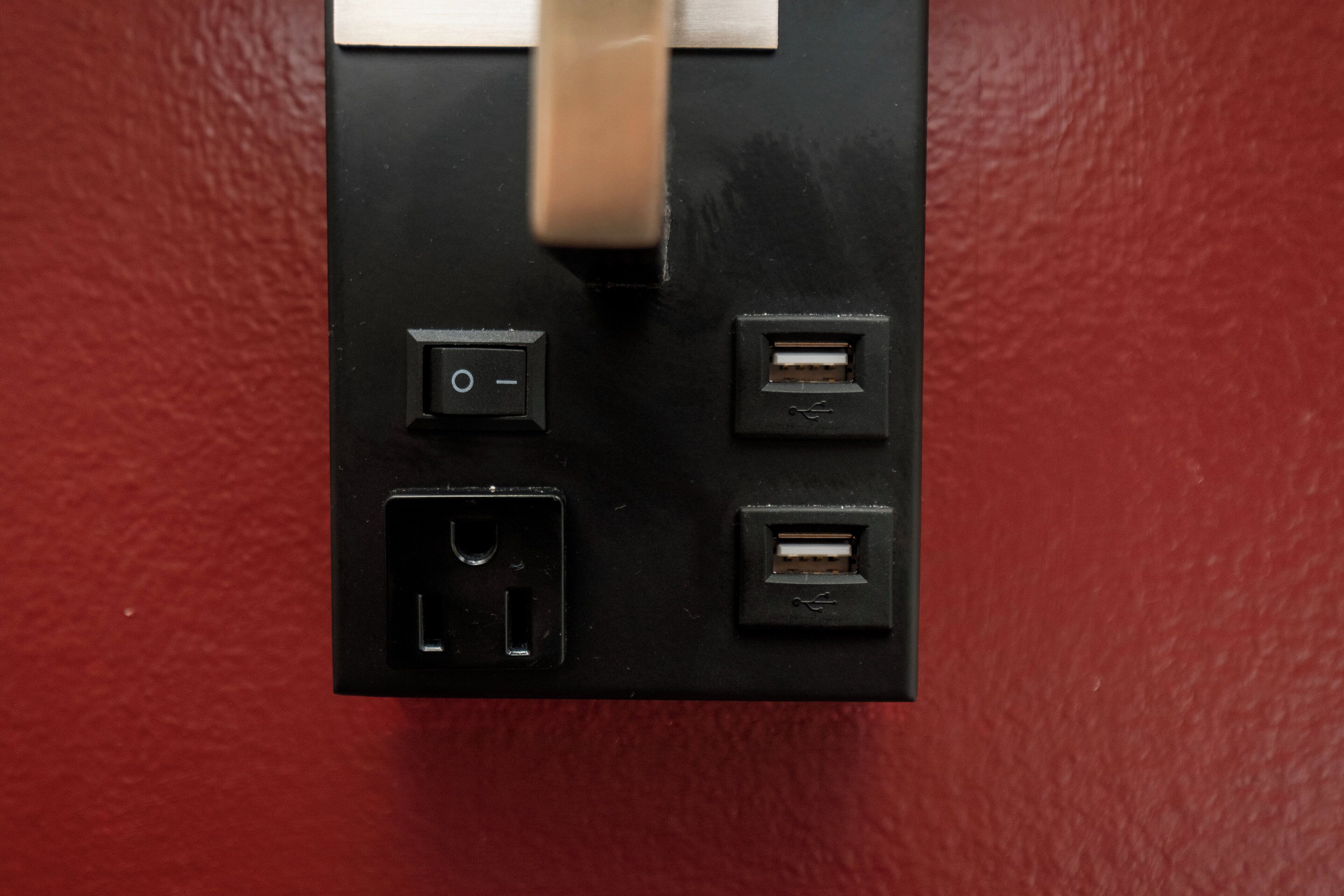 A black electrical panel with four USB ports and a power switch.