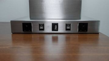 A metallic device with four ports on a wooden surface.