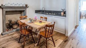 Une cuisine avec un coin repas, des chaises en bois, une cheminée et un évier moderne.