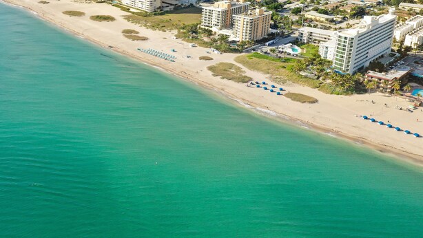 An aerial view of a beach with a hotel complex.