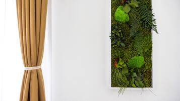 Een verticale wandtuin met verschillende planten en een gordijn aan de linkerkant.