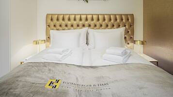 A neatly made bed with a tufted headboard, white linens, and two bedside lamps.