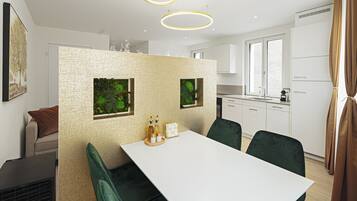 Een moderne keuken met witte kasten, een wit aanrecht en een eethoek met een witte tafel en groene stoelen. Boven de tafel hangen twee hanglampen.