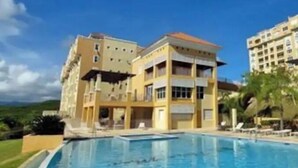 Ein Hotel mit Schwimmbad, mehreren Balkonen und Blick auf die umliegende Landschaft.