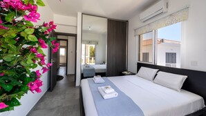 Ein modernes Hotelzimmer mit einem großen Bett, einem Nachttisch, einem Spiegel und einem Fenster mit Blick nach außen.