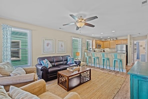 A living room with a sofa, coffee table, and a ceiling fan.