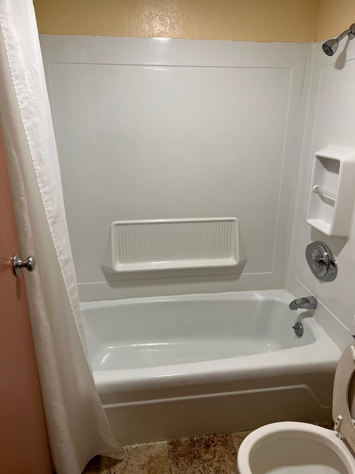 A bathroom with a bathtub, a toilet, and a shower.