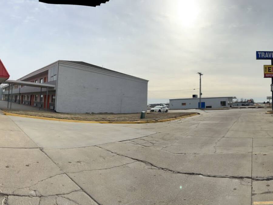 A gas station with a red roof and a sign for Travelers Lodge.