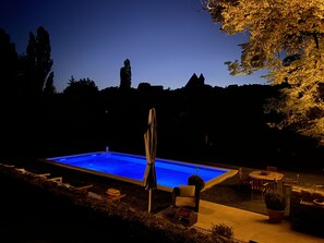 Een seizoensgebonden buitenzwembad en parasols bij het zwembad