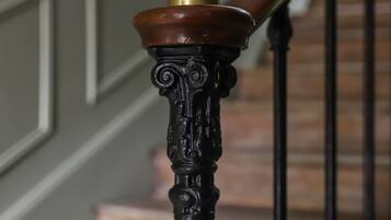 Un escalier orné de balustres noirs et d’un pompon en laiton.