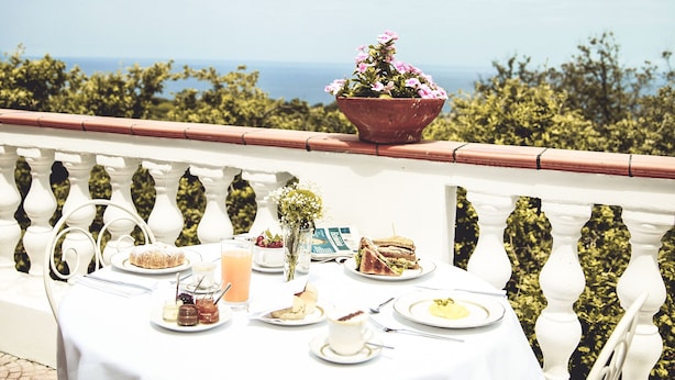 A table set for a meal on a balcony with a view of the sea. - Tenuta Tropeano (Ricadi)