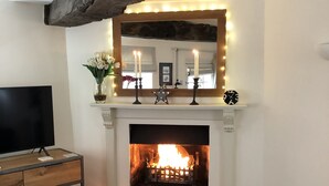 A living room with a fireplace, a television, and a sofa. - AWARD WINNING Shining Star on the Historic Cartway with River Views (Bridgnorth)