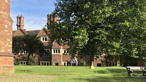 A large brick building with multiple chimneys, surrounded by a well-maintained lawn and trees. - AWARD WINNING Shining Star on the Historic Cartway with River Views (Bridgnorth)