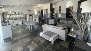 A spacious living area with a modern kitchen, a dining table, and a comfortable sofa. - Villa Cava with private pool (Avola)