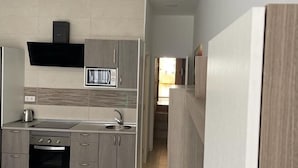 Una cocina moderna con armarios grises, horno integrado y microondas.