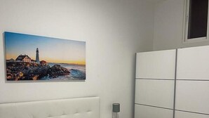 Un dormitorio con cama, mesita de noche, lámpara y armario.