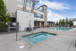 Relax by the pool surrounded by a paved deck and lounge chairs.