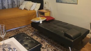 A bedroom with a bed, bedside table, bench, and a painting on the wall. - Great Delray, Alexandria, One bed, bath, kitchen NOT share, big backyard, metro, (Alexandria)