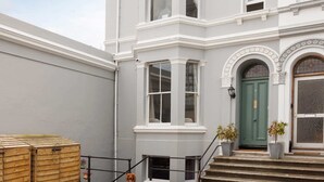 A two-story building with a green door, white trim, and a small front garden with steps leading to the entrance. - Luxury for 2024, Central Plymouth Home for 10 (Plymouth)