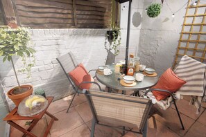 A round table with chairs, a potted plant, and a hanging plant.