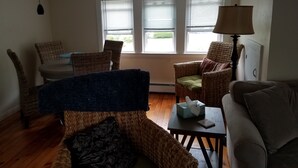 Ein Wohnzimmer mit Korbmöbeln, einem Tisch mit Taschentuchbox und einer Lampe.