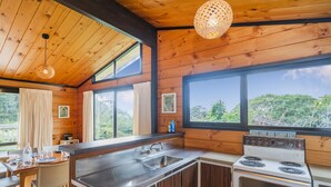 Una cocina moderna con paredes de madera, un ventanal grande y una estufa.