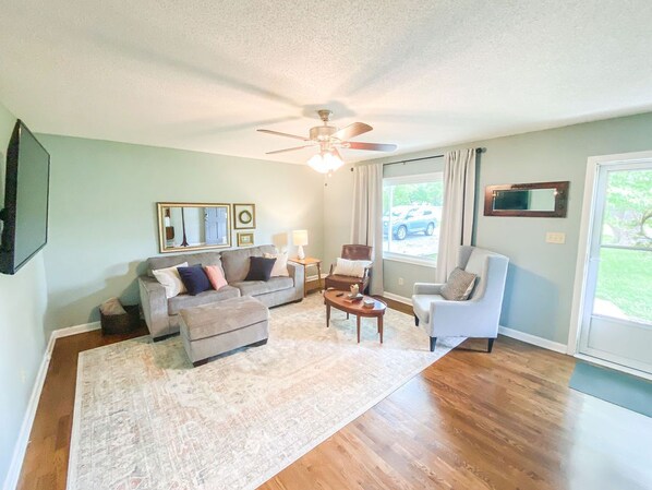 A living room with a sofa, armchairs, a coffee table, and a ceiling fan. - The Aviary Cottage: Bunkbed, Near Playground, Swing, Full Fence, Central to all (Springfield)