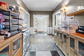 Un couloir avec une vitrine, un meuble en bois et un tapis.