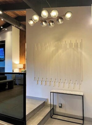 Un interior moderno con un aplique de pared y un diseño de panel de madera vertical.