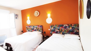 Habitación de hotel con dos camas, un escritorio, una silla y un televisor.